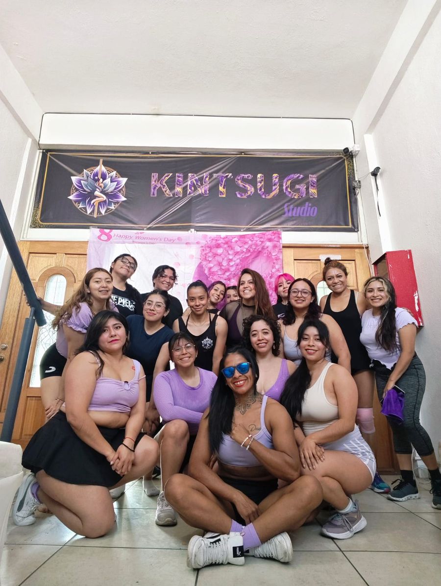 Alumnas de Kintsugi Studio reunidas bajo el letrero del estudio en la celebración del Día de la Mujer